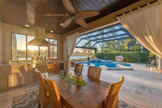 view of patio / terrace featuring glass enclosure, area for grilling, a ceiling fan, and a sink