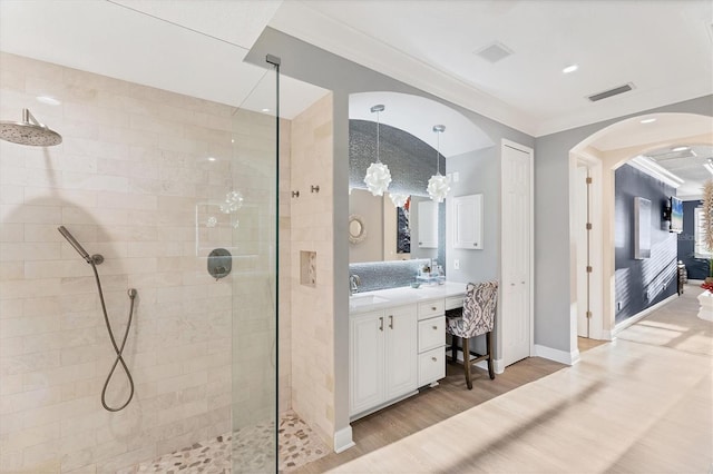 full bathroom with visible vents, ornamental molding, a walk in shower, wood finished floors, and vanity