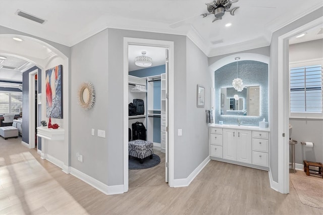 ensuite bathroom with crown molding, a healthy amount of sunlight, and visible vents