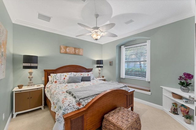 bedroom featuring visible vents, baseboards, ornamental molding, light carpet, and a ceiling fan