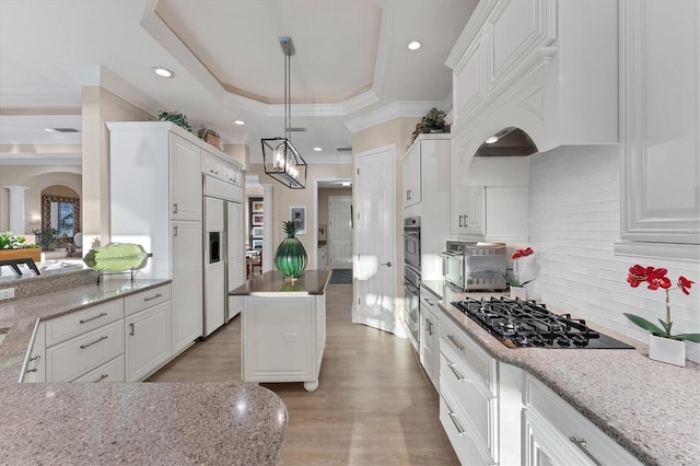 kitchen with white cabinetry, a raised ceiling, black gas stovetop, and arched walkways