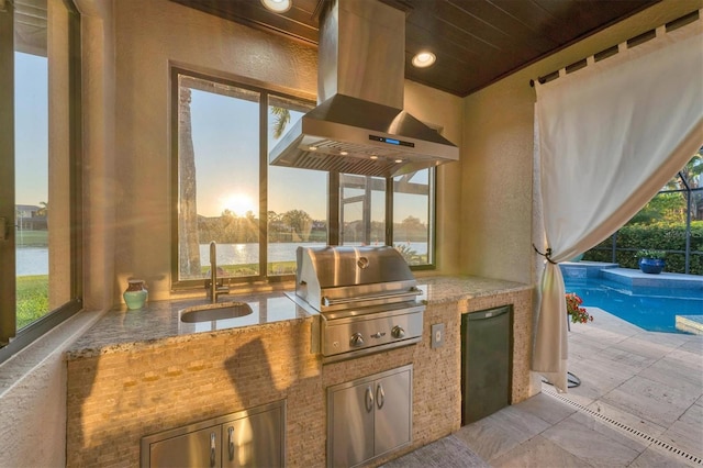 view of patio / terrace featuring a grill, glass enclosure, an outdoor kitchen, an outdoor pool, and a sink