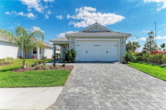 ranch-style home with decorative driveway, an attached garage, a front lawn, and stucco siding