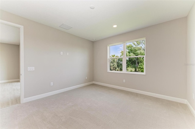 unfurnished room with recessed lighting, baseboards, and light colored carpet