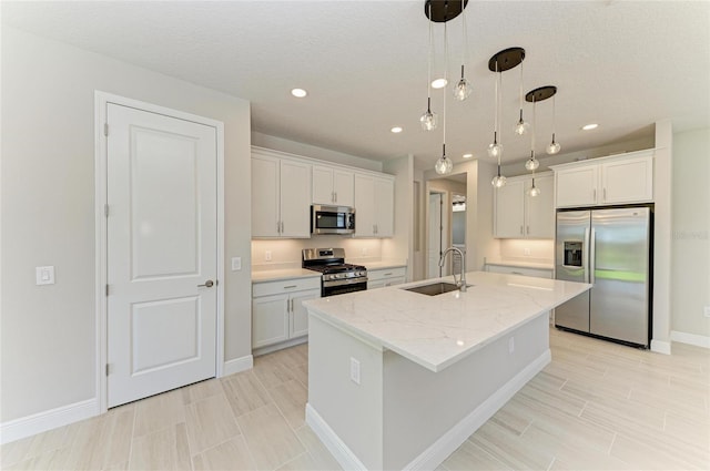 995 Waterline Ct, Sarasota, FL 34240 - kitchen featuring stainless steel appliances, white cabinets, a kitchen island with sink, and a sink