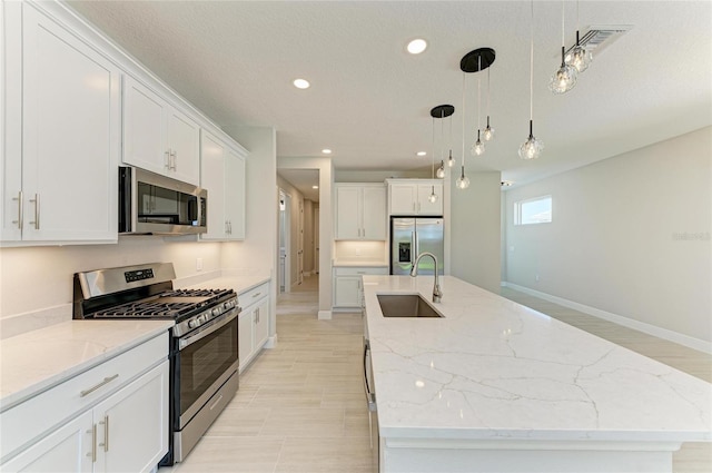 995 Waterline Ct, Sarasota, FL 34240 - kitchen featuring pendant lighting, a large island, stainless steel appliances, white cabinetry, and a sink