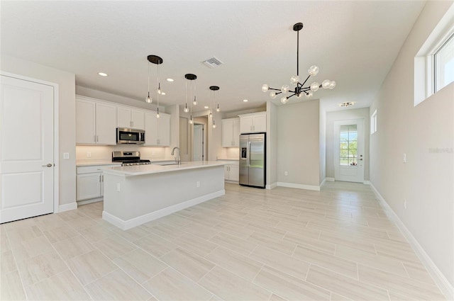 995 Waterline Ct, Sarasota, FL 34240 - kitchen with light countertops, visible vents, appliances with stainless steel finishes, white cabinetry, and a sink