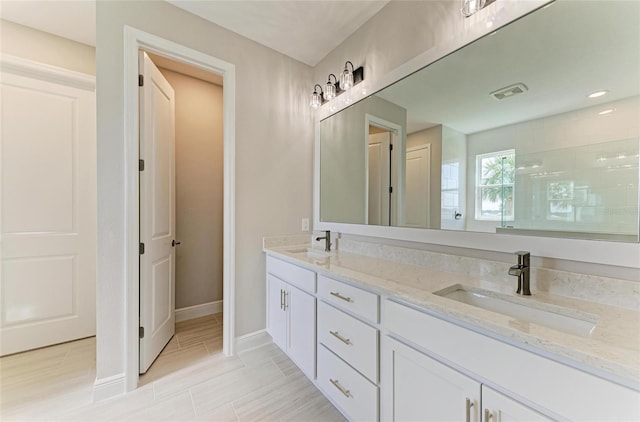 995 Waterline Ct, Sarasota, FL 34240 - full bathroom with double vanity, visible vents, a tile shower, and a sink