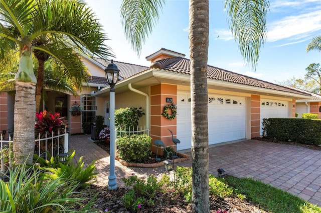 view of front of home with an attached garage, stucco siding, and a tiled roof