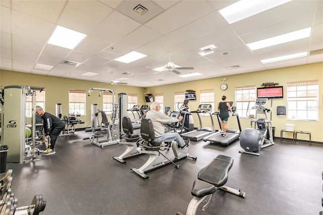 gym with a ceiling fan, a drop ceiling, visible vents, and a wealth of natural light