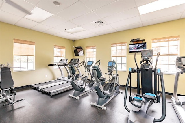 workout area with baseboards, visible vents, and a drop ceiling