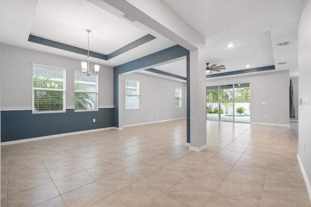 unfurnished room featuring baseboards, visible vents, a tray ceiling, light tile patterned flooring, and ceiling fan with notable chandelier