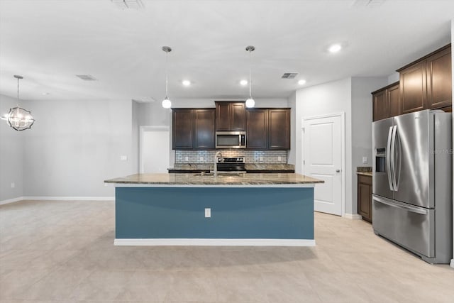 kitchen with stainless steel appliances, visible vents, dark brown cabinets, and dark stone countertops