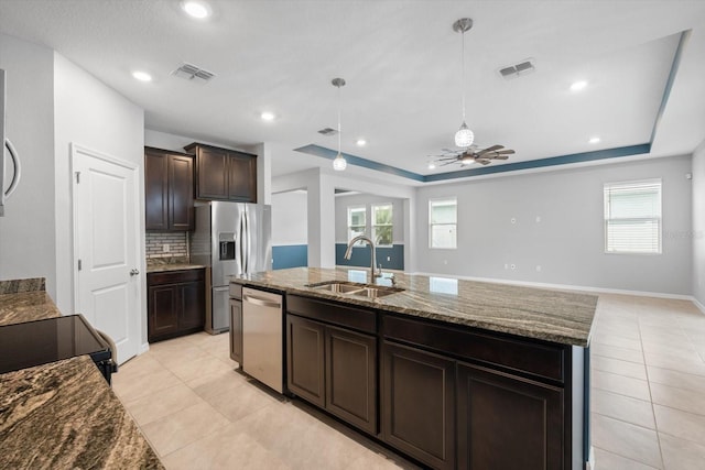 kitchen featuring a raised ceiling, appliances with stainless steel finishes, a sink, and visible vents