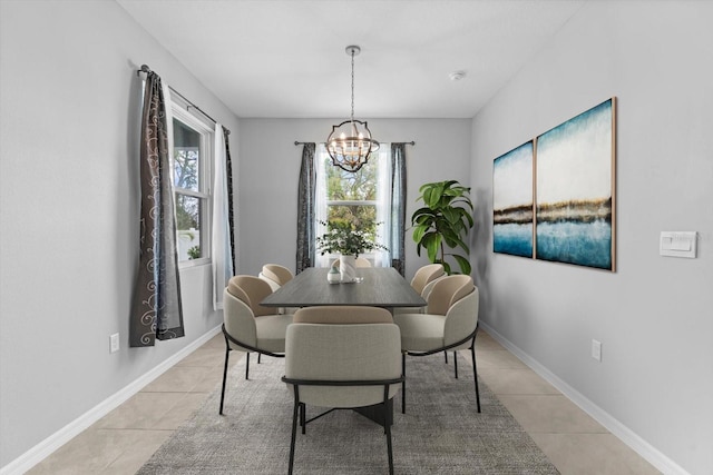 dining space with baseboards, a notable chandelier, and light tile patterned flooring