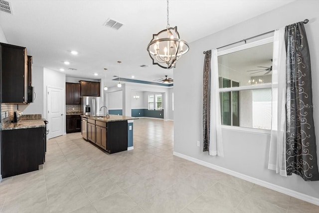 kitchen with tasteful backsplash, visible vents, open floor plan, stainless steel appliances, and ceiling fan with notable chandelier