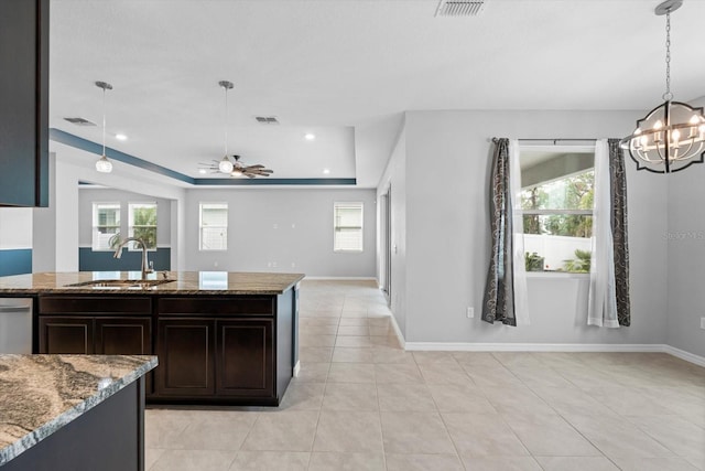 kitchen featuring light tile patterned floors, stone countertops, visible vents, dishwasher, and a sink