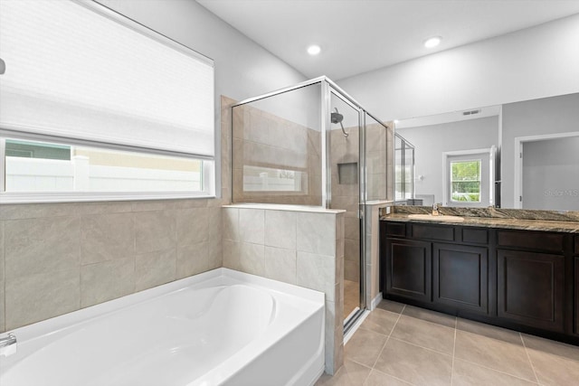 bathroom featuring vanity, a shower stall, a bath, and tile patterned floors