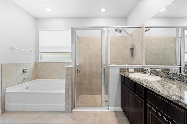 full bathroom featuring tile patterned floors, a shower stall, a garden tub, and vanity