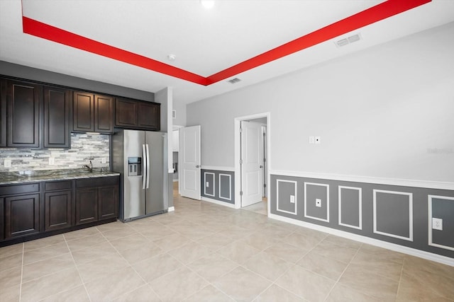 kitchen featuring light tile patterned floors, tasteful backsplash, visible vents, and stainless steel refrigerator with ice dispenser