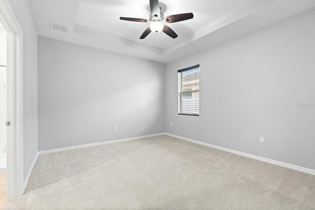 unfurnished room with light carpet, baseboards, and a tray ceiling