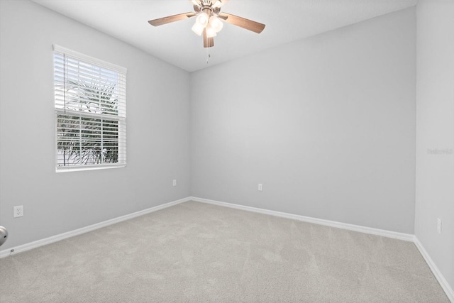 spare room featuring ceiling fan, carpet, and baseboards