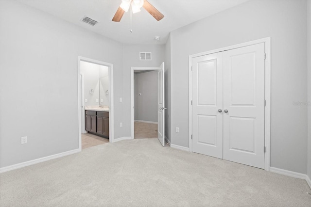 unfurnished bedroom with a closet, visible vents, light carpet, and baseboards