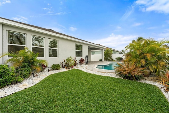 back of house featuring a fenced in pool, fence, a yard, a patio area, and stucco siding