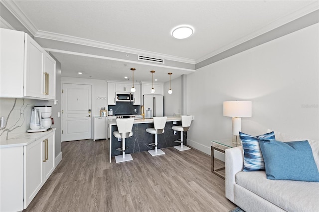 kitchen with open floor plan, high end fridge, wood finished floors, and a kitchen breakfast bar