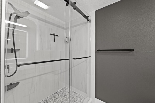 bathroom featuring a shower stall and a textured ceiling