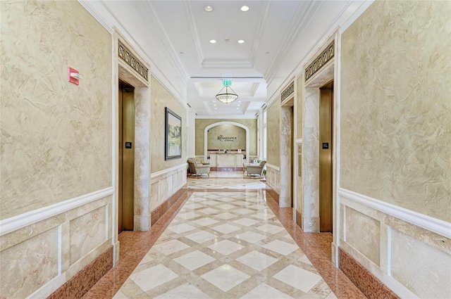 hallway with arched walkways, recessed lighting, a textured wall, ornamental molding, and wainscoting