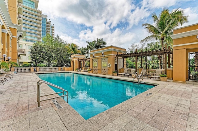 community pool with a patio area and fence