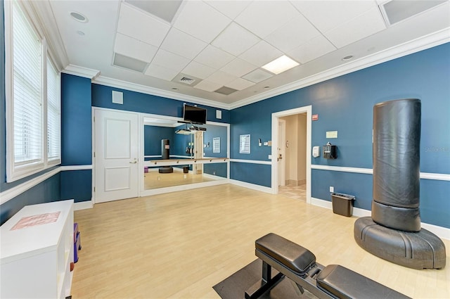 workout room featuring baseboards, visible vents, wood finished floors, crown molding, and a paneled ceiling