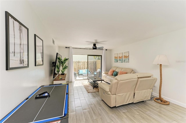 living area with wood finish floors, visible vents, ceiling fan, and baseboards