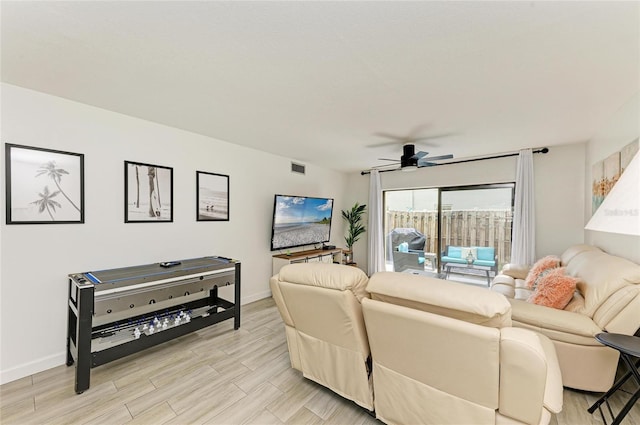 living room with baseboards, a ceiling fan, visible vents, and light wood-style floors