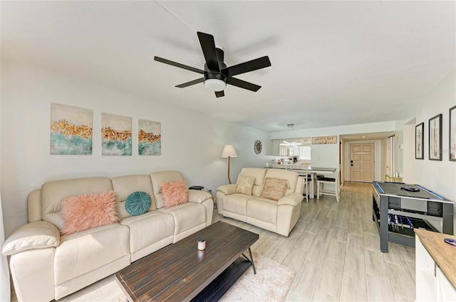 living area with ceiling fan and light wood finished floors