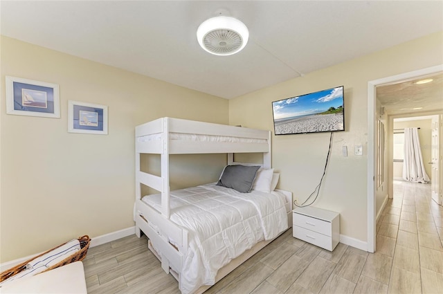 bedroom with baseboards and wood tiled floor