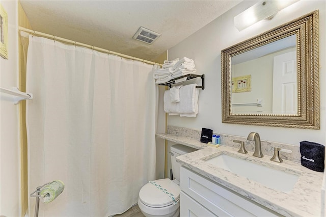 bathroom featuring toilet, a textured ceiling, vanity, and visible vents