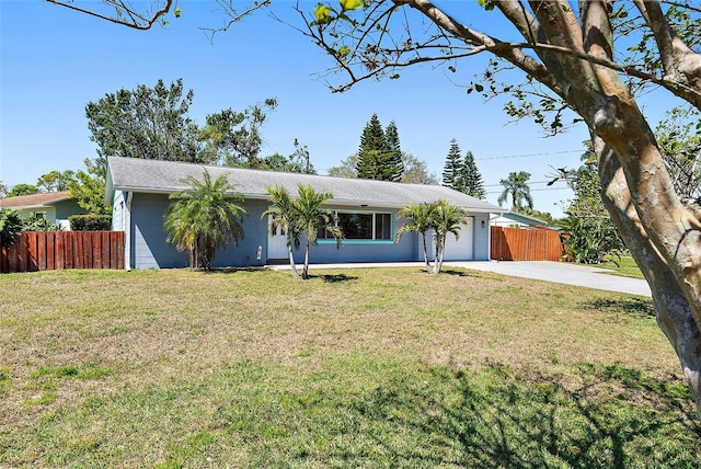 ranch-style house featuring a front yard, an attached garage, driveway, and fence