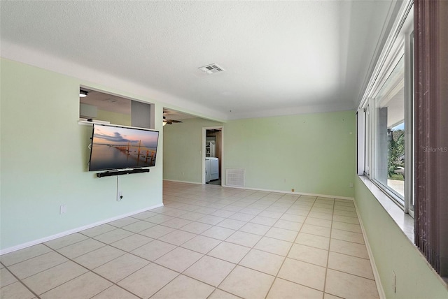 unfurnished room featuring light tile patterned floors, baseboards, visible vents, and a textured ceiling