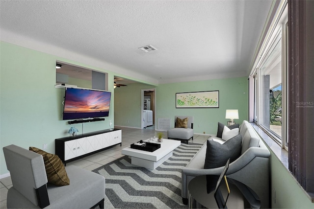 living room with visible vents, a textured ceiling, and tile patterned flooring