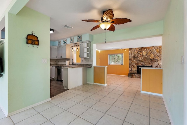 kitchen featuring visible vents, ceiling fan, light tile patterned floors, a peninsula, and a sink