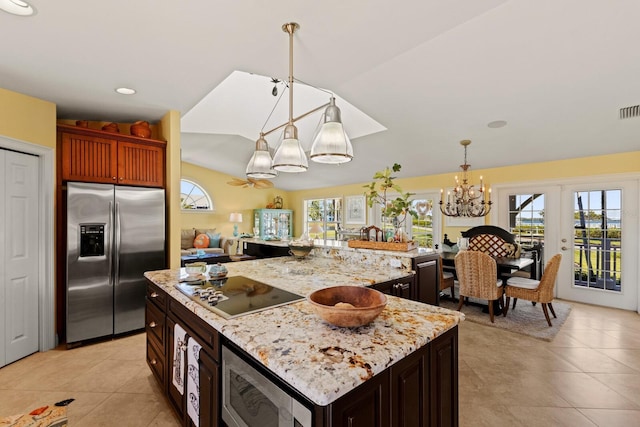 kitchen with hanging light fixtures, light stone countertops, visible vents, and appliances with stainless steel finishes