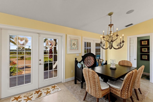 dining space with visible vents, baseboards, lofted ceiling, french doors, and a notable chandelier