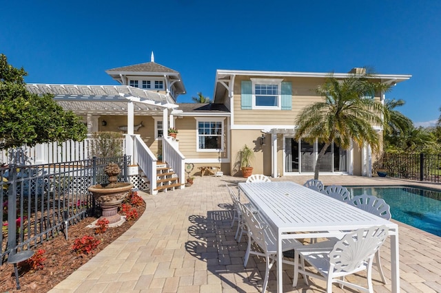 rear view of property with a fenced in pool, a patio, a fenced backyard, and a pergola