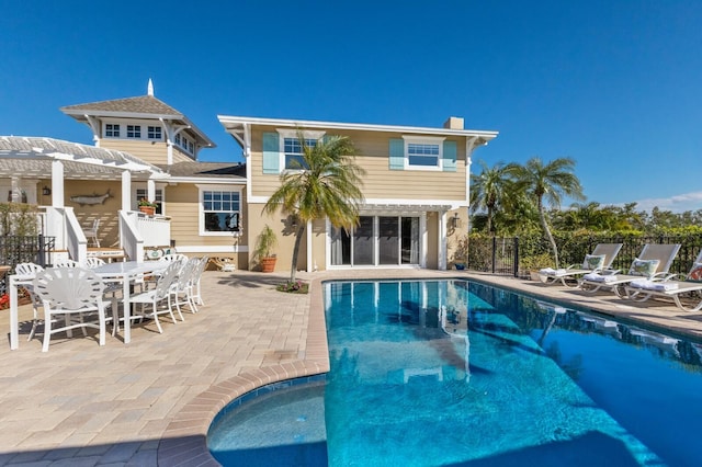 rear view of house with a patio, a fenced in pool, fence, and a pergola