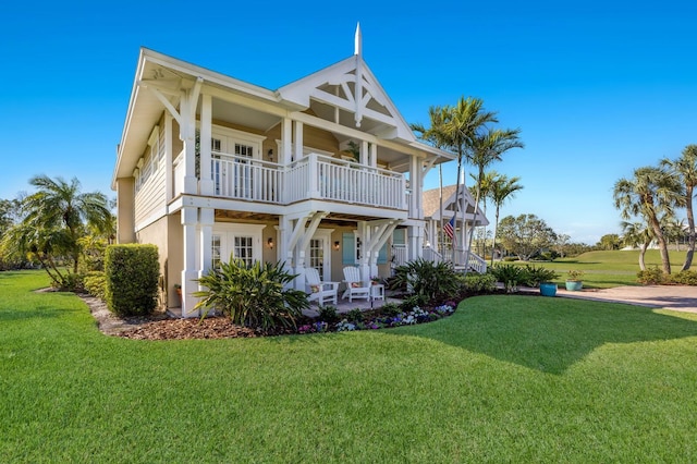 back of house featuring a yard, a patio, and a balcony