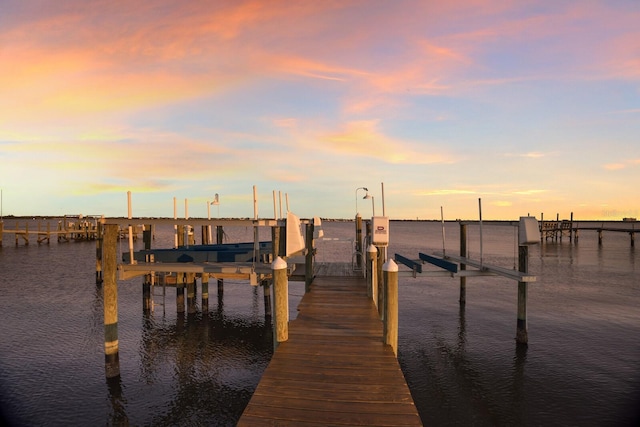 dock area with boat lift and a water view