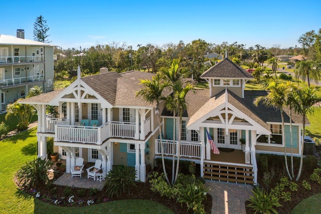 rear view of house with a patio area, a yard, french doors, and roof with shingles