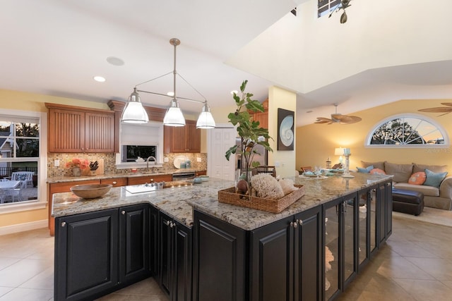 kitchen with open floor plan, backsplash, and dark cabinetry